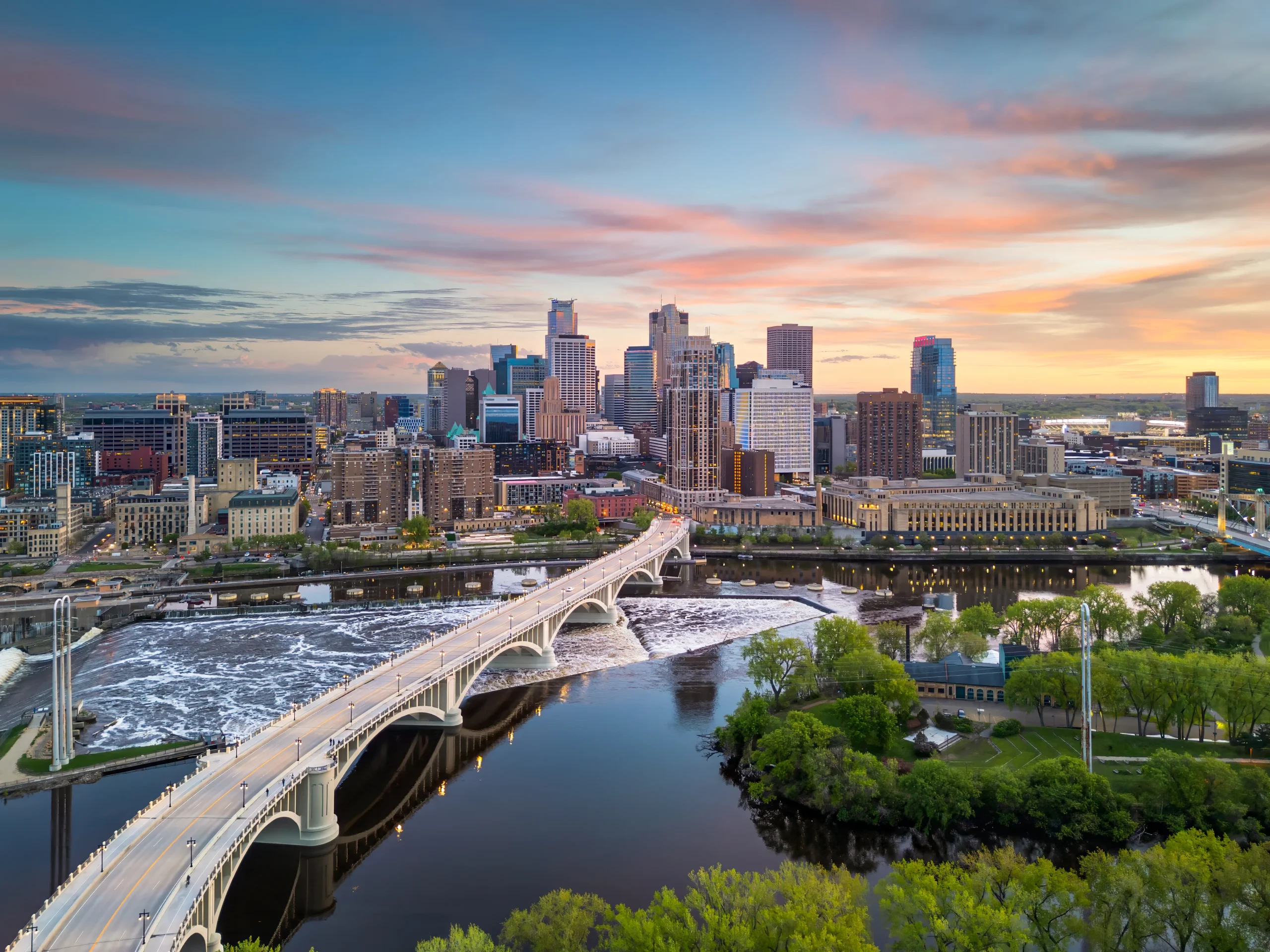 Downtown Minneapolis skyline and Mississippi River at sunset